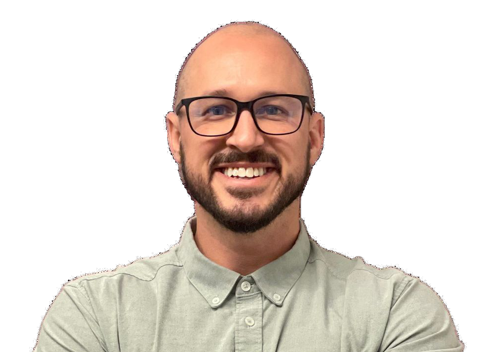 Dr. Brent Jenogan smiling with arms crossed, in glasses and a gray button shirt.